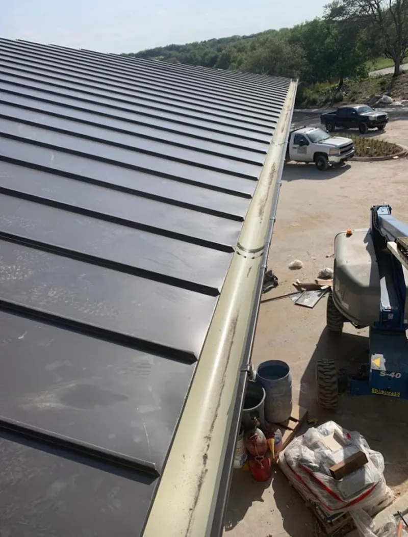 Standing seam panel and gutter detail on a metal roofing jobsite in Kings Grant